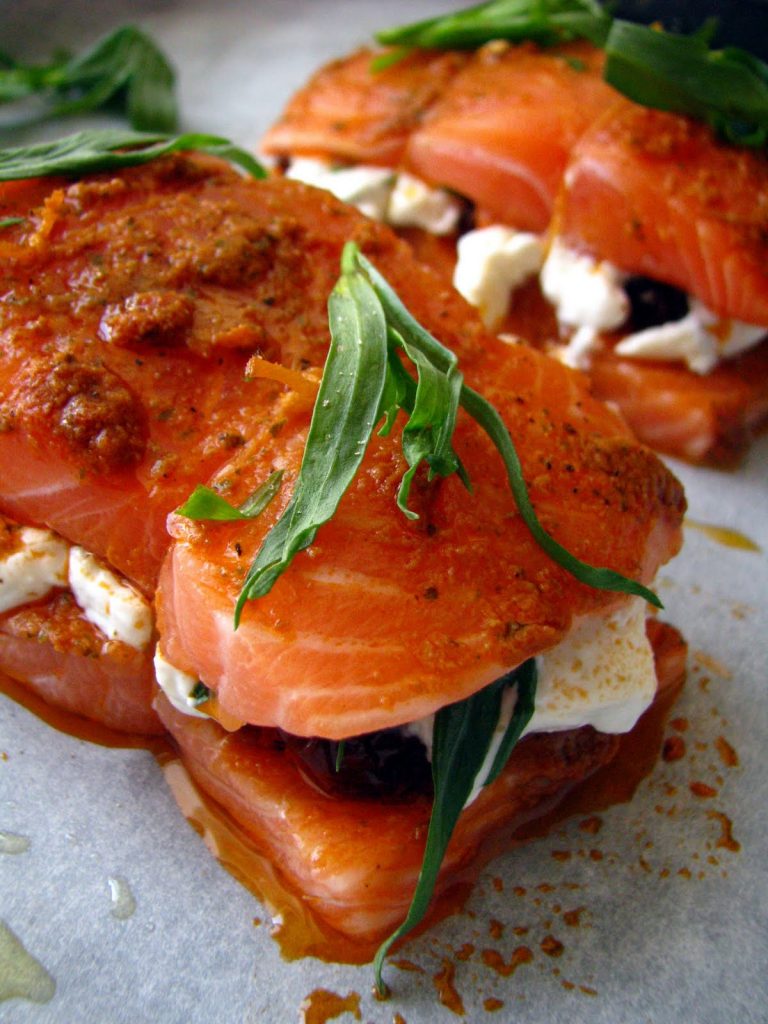 Petit rôti de saumon maison garni de ricotta, pesto rosso et tomates séchées prêt à être enfourné au four. Cuisson en papillote pour un résultat très moelleux et léger. 