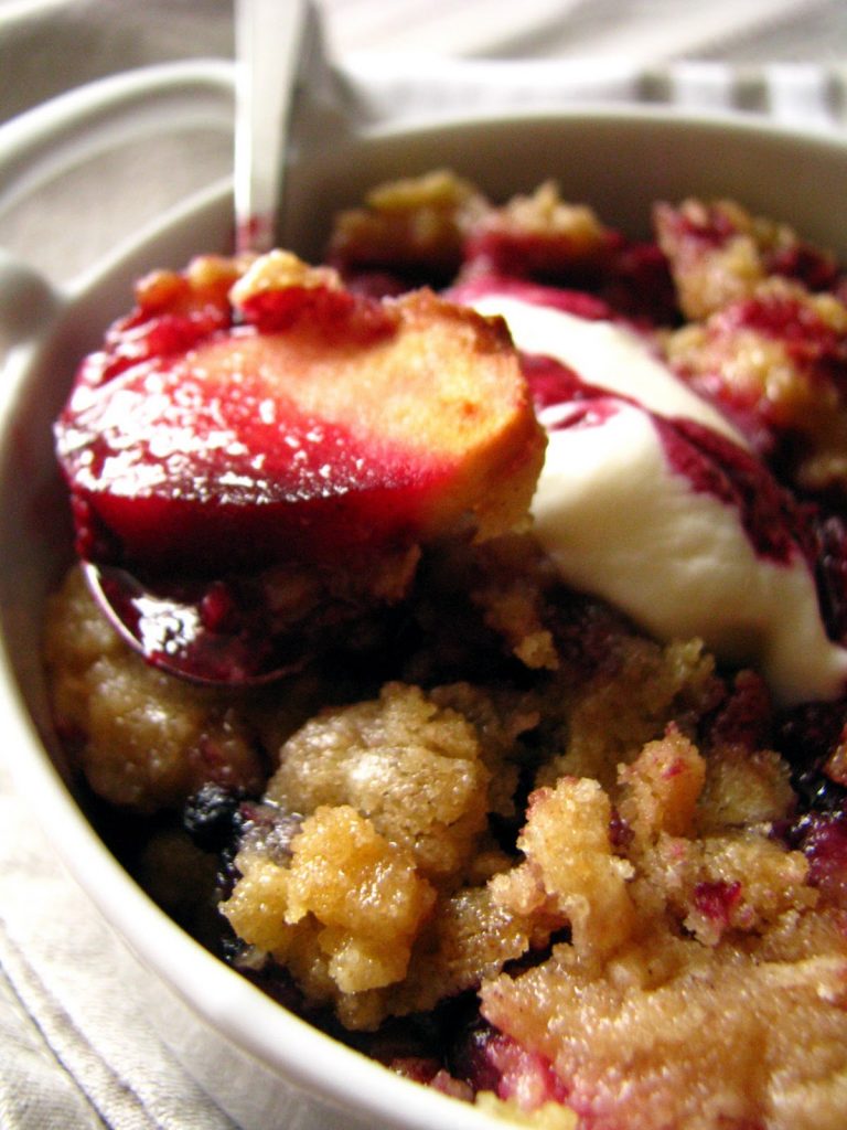 Crumble comme en Angleterre aux pommes et aux myrtilles, servi avec de la crème fraîche épaisse.