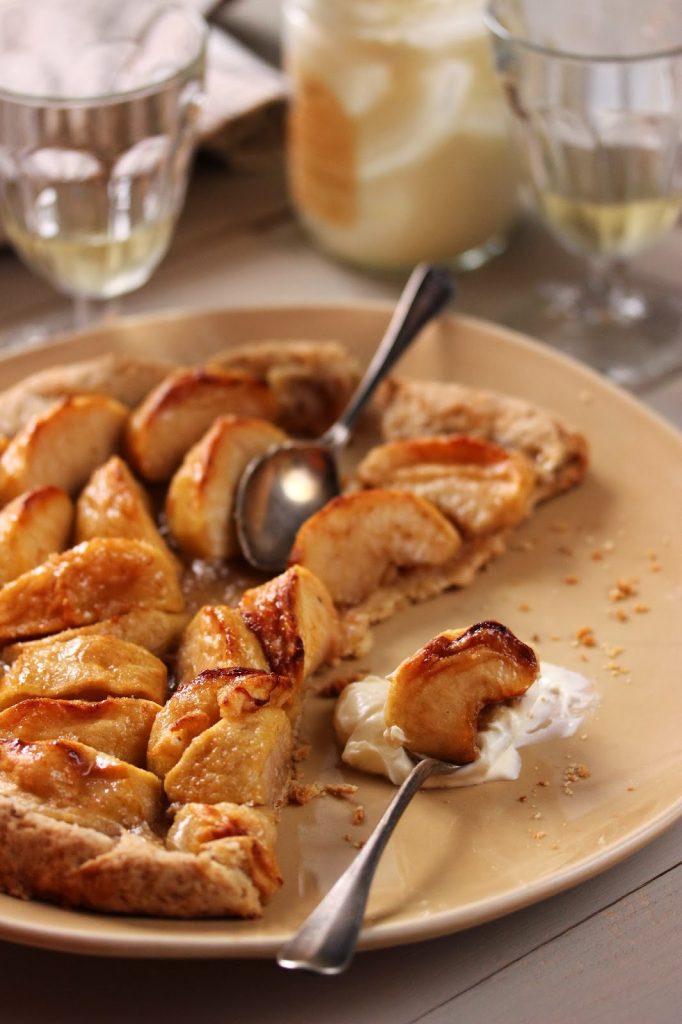 Tarte aux pommes rustique avec de généreux morceaux de fruits et servie tiède avec de la crème fraîche