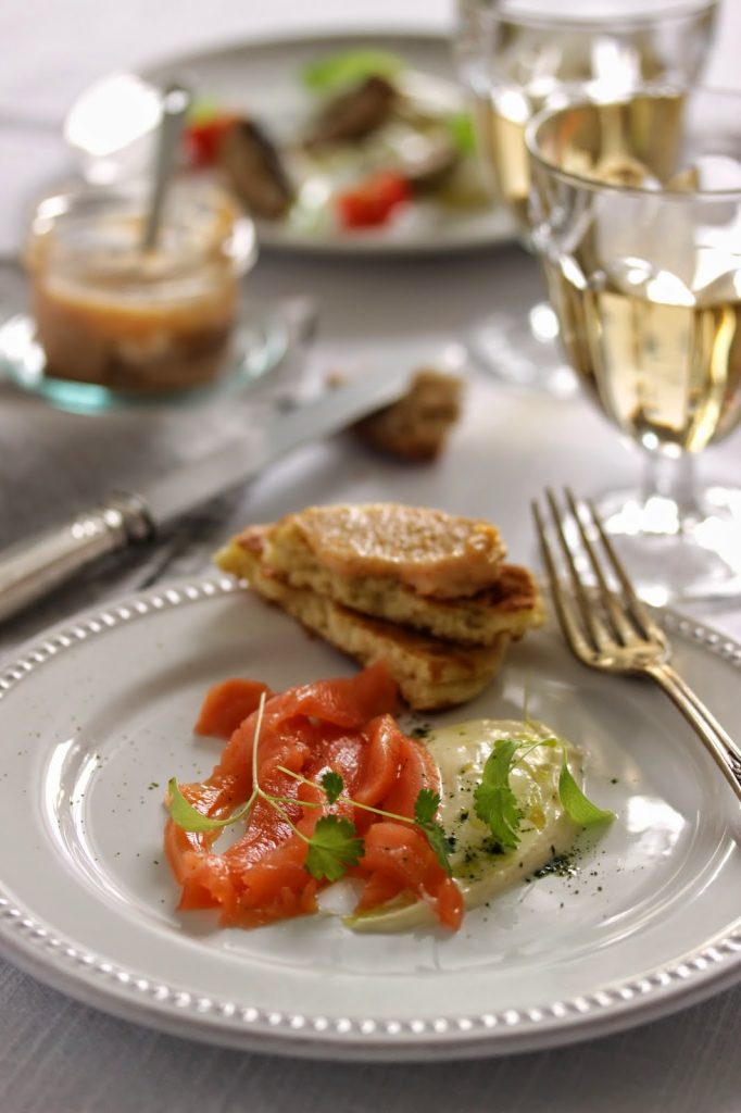 Salade de saumon fumé détaillé en fines lamelles et servi avec une sauce à la crème fraîche et matcha. 