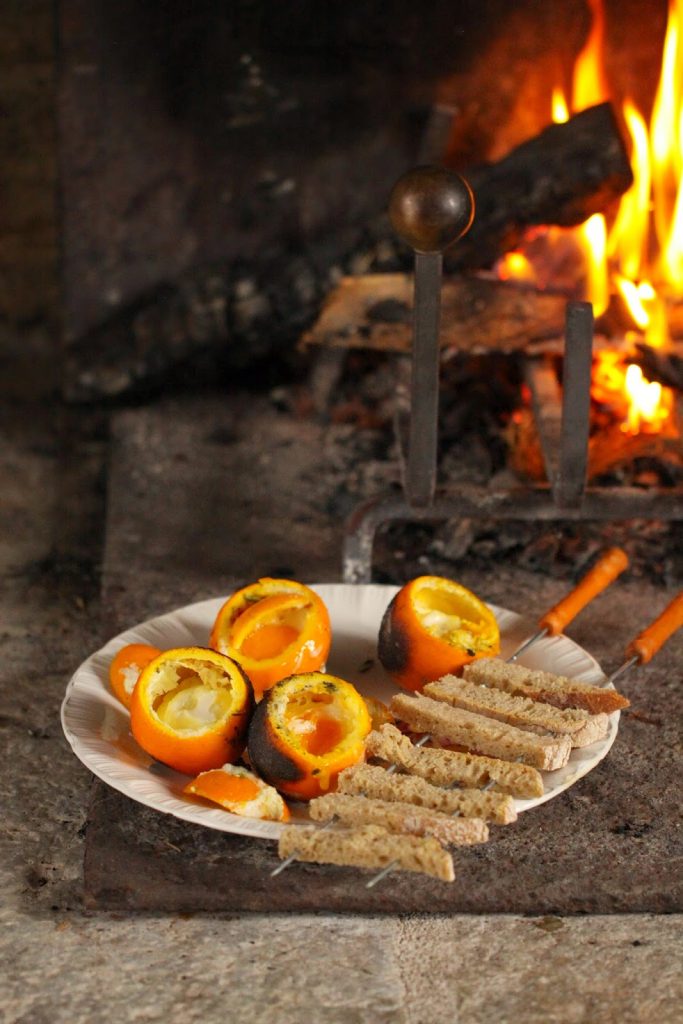 Oeuf cocotte dans une orange cuite à la braise accompagné de mouillettes de pain de campagne