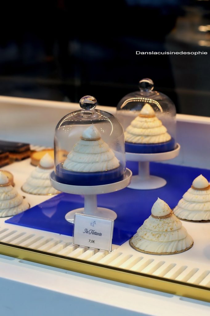 Ile flottante, dessert signature de la Maison Senoble posés en vitrine sur une plat à pied recouvert d'une cloche en verre