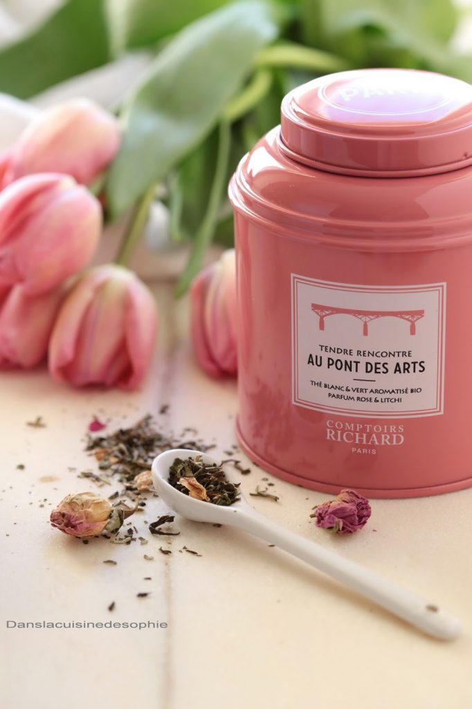 Boîte de thé Tendre rencontre au pont des arts avec cuillère présentant le thé (thé vert et roses) dans une ambiance douce et printanière 