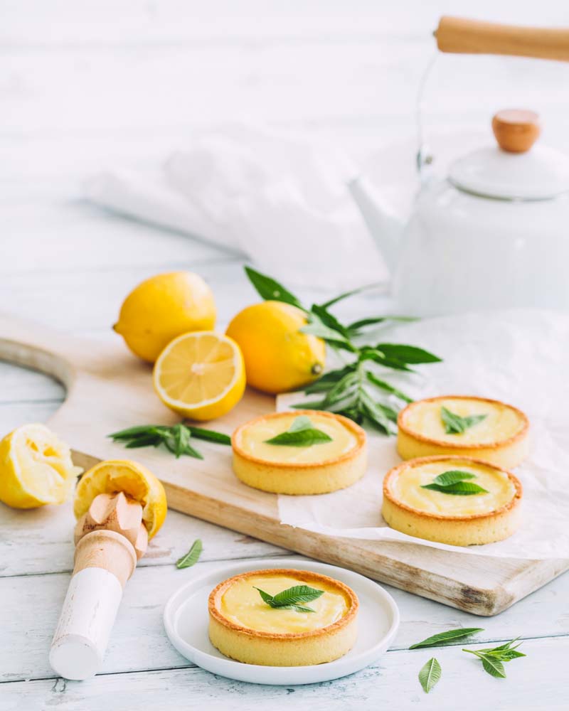 Tartelettes individuelles au citron - crème sans cuisson - présentées sur planche. Une recette facile et rapide.