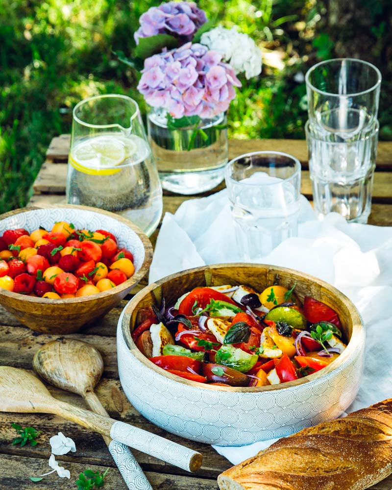 Salade de tomates multicolores avec de l'haloumi grillé pour un repas estival, sain et végétarien. 