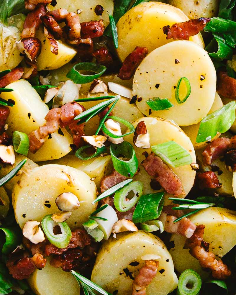 Gros plan sur la salade de pommes de terre primeur aux lardons fumés, noisette, romarin et cébette. 