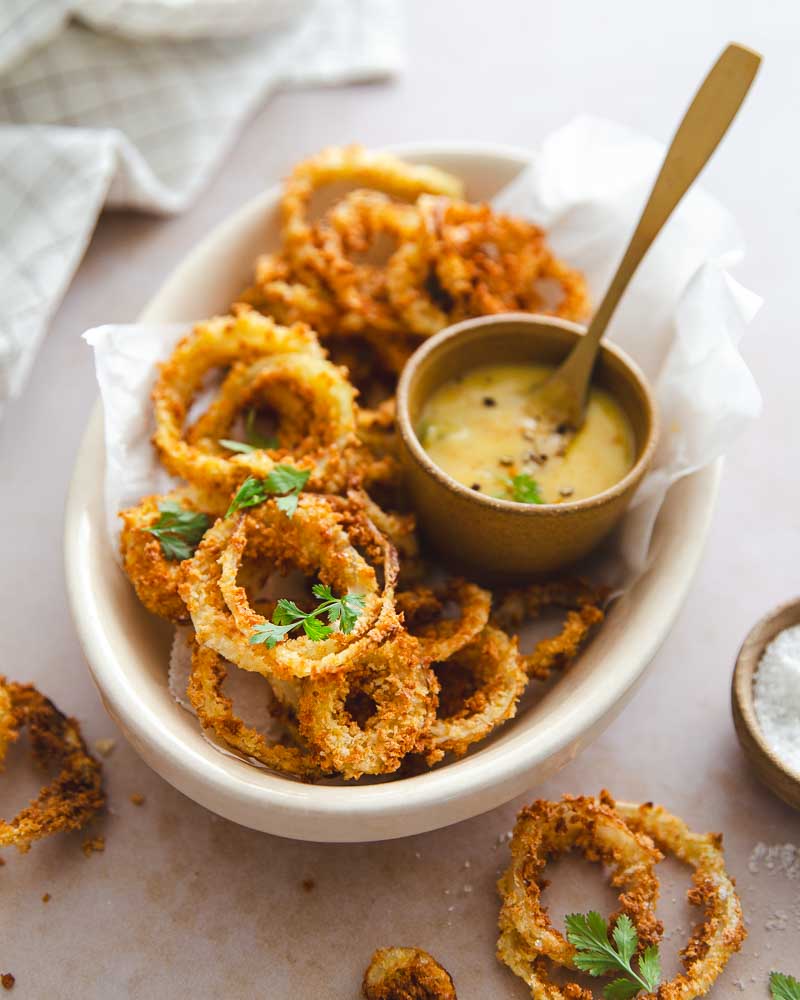 Onion rings réalisés en quelques minutes avec une cuisson à l'Air Fryer : un snack ou apéritif léger et délicieux sans goût de gras. A servir avec un mayo au curry, recette maison. 