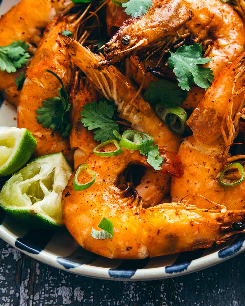 Gros plan sur des crevettes cuites à l'air Fryer préalablement marinées avec ail, gingembre, sauce soja, citron vert et huile 