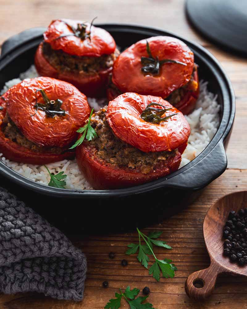 Plat de tomates farcies à la viande de boeuf et à la chair à saucisse cuisinée s avec de 'l'oignon, de l'ail et du persil avec du pain rassis. 