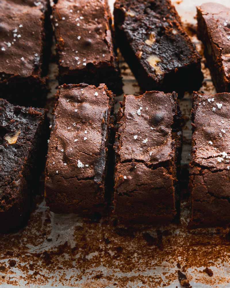 Brownie découpé en parts, prêt à être dégusté avec des grains de fleur de sel pour équilibrer le goût du chocolat. 