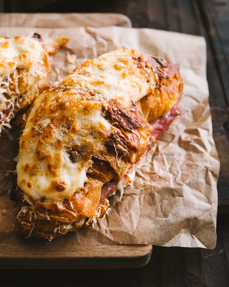 Croissant garni de sauce Béchamel, de jambon blanc et de fromage puis recouvert de sauce Béchamel et de fromage afin d'être gratiné au four.