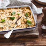 Gratin de courgettes vegetal posé sur une table en bois rustique