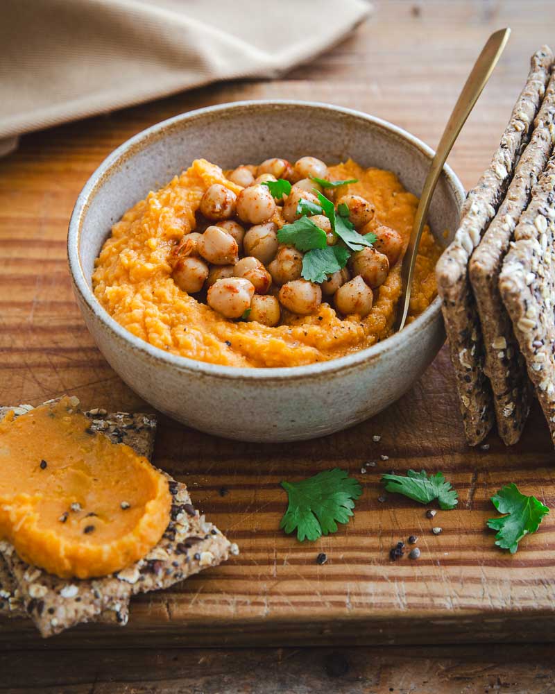 Bol de houmous de patate douce à l'huile de sésame et pois chiches au paprika