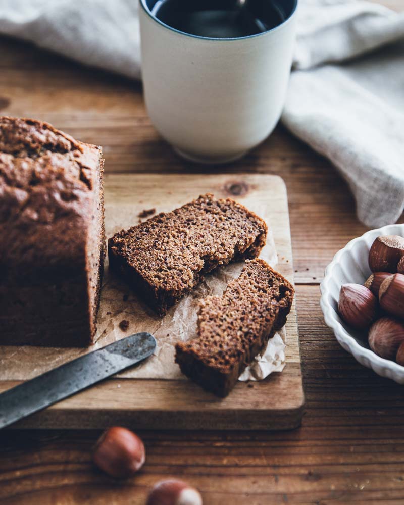 Cake aux noisettes healthy avec du sucre de coco prêt à être dégusté. Ambiance chaleureuse sur table en bois