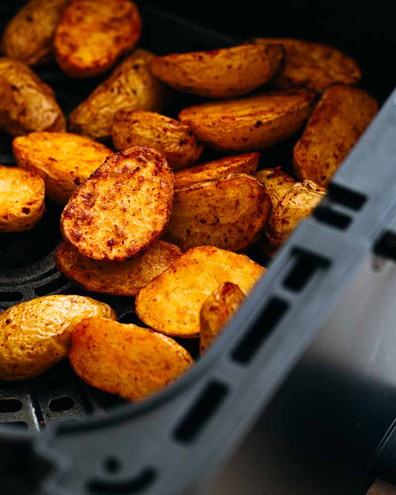 Pommes de terre grenaille coupées en deux, rôties à l'Airfryer encore dans le panier de cuisson