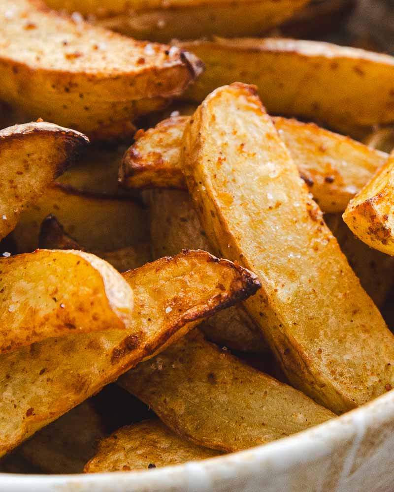 Gros plan sur des quartiers de pommes de terre cuites à l'Air Fryer pour en faire des potatoes