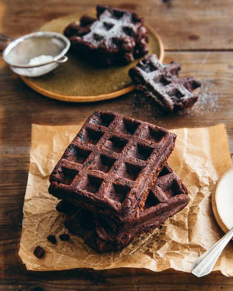 Gaufres brownies aux noix de pécan, emplilées et posées sur un papier cuisson : recette de Michel et Augustin, les trublions du goût