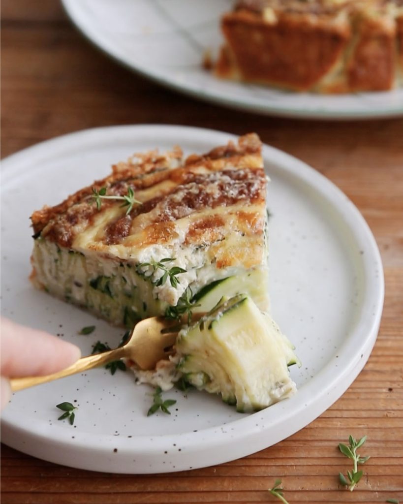 Part de quiche spirale aux courgettes en train d'être dégustée
