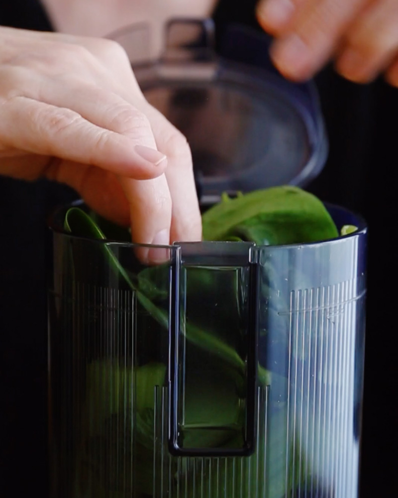 Insertion des légumes dans le bol de l'extracteur de jus Hurom