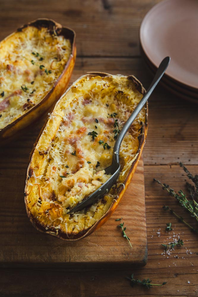 Courge spaghetti farcie façon carbonara sur planche en bois avec une cuillère vintage