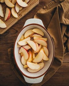 Clafoutis aux pommes ig bas pommes coupées dans le plat allant au four